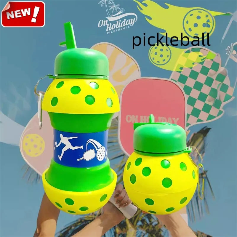 A hand holds a bright yellow and green silicone sports water bottle with a polka dot design against a tropical background.