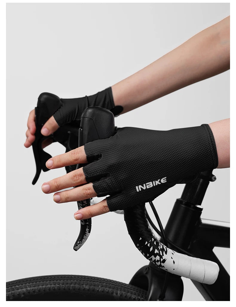 A hand wearing black Inbike half-finger cycling and MTB gloves is gripping a bicycle handlebar.