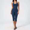 A woman wearing a navy blue women's premium fitness tracksuit top and leggings.