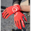 A close-up of a red performance cycling glove with a white logo on a hand gripping a bicycle handlebar.