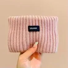 A light pink knitted headband with the brand name 'FRANK' visible on the front.