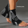 Black and grey compression sleeves for ankle joints worn on a foot.