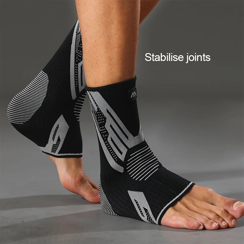 Black and grey compression sleeves for ankle joints worn on a foot.