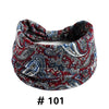 A close-up of a red and blue paisley print boho cotton headband for hair or workout.