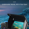 A black handheld underwater camera is shown with a lens pointed at a colorful marine scene.