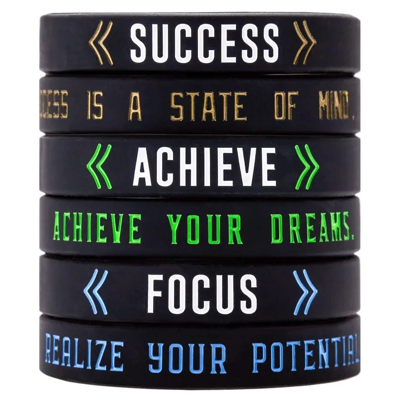 A set of five black silicone wristbands with motivational words like Success, Achieve, Focus, and Realize your Potential