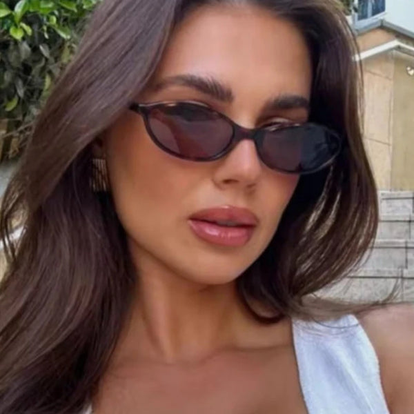 صورة مقربة لامرأة ترتدي نظارات شمسية بإطار بيضاوي بني عتيق.
