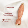 A wooden massage stick with round brass beads, featuring an ergonomic design.