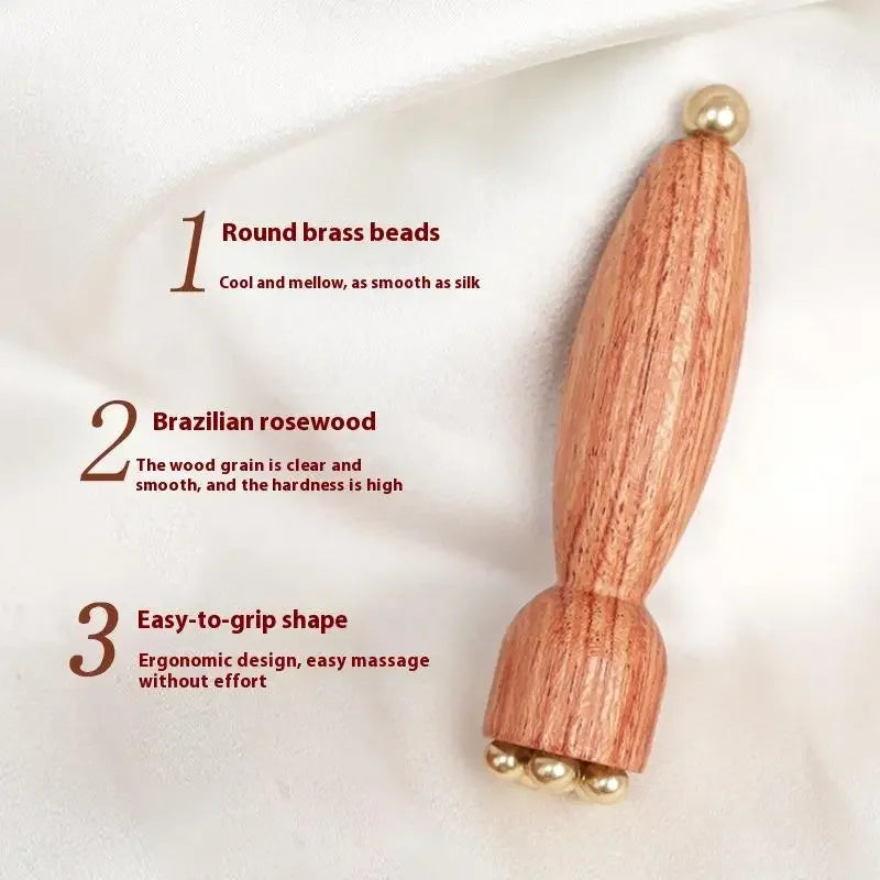 A wooden massage stick with round brass beads, featuring an ergonomic design.