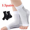 One pair of white compression ankle support braces shown on a foot and leg.