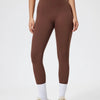 Model wearing seamless high-waist yoga leggings and a matching cropped top in brown.