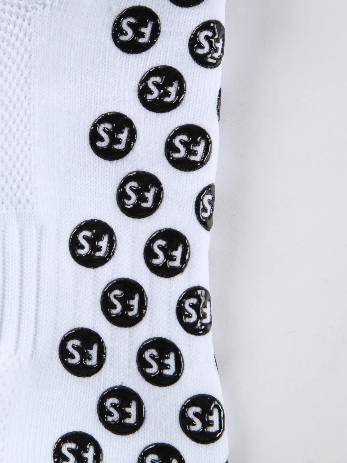 White athletic soccer socks with black anti-slip grip pattern on the calf.