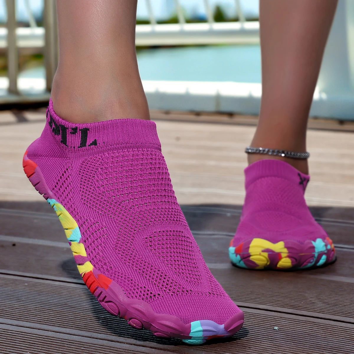 A close-up of a bright pink waterproof quick-dry outdoor hiking shoe worn on a person's foot.