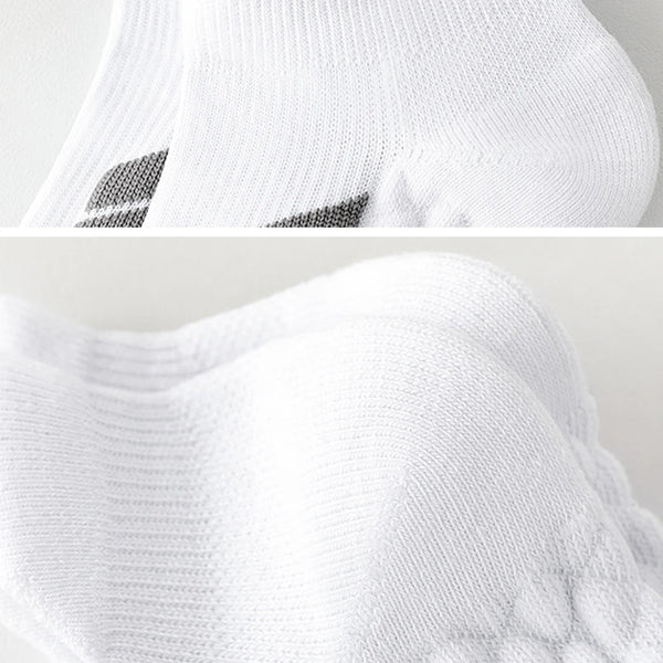 Gros plan de chaussettes de sport blanches à rayures noires, montrant la texture du tricot et le détail du col.