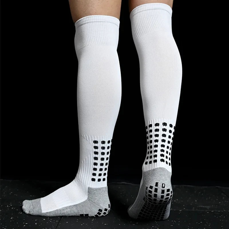 A pair of white long football training socks with a black grid pattern near the ankle.