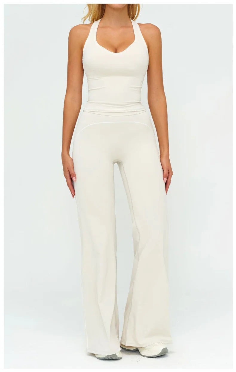 Una mujer modela un conjunto de ropa deportiva de yoga color crema, de cintura alta, compuesto por un top corto y pantalones 