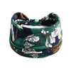 A dark blue and green floral patterned bohemian cotton stretch headband worn around the neck.