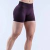 A model is wearing seamless high-waisted yoga shorts in a deep purple color.