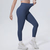 A model wearing navy blue high-waisted yoga leggings and white socks, standing against a light background.