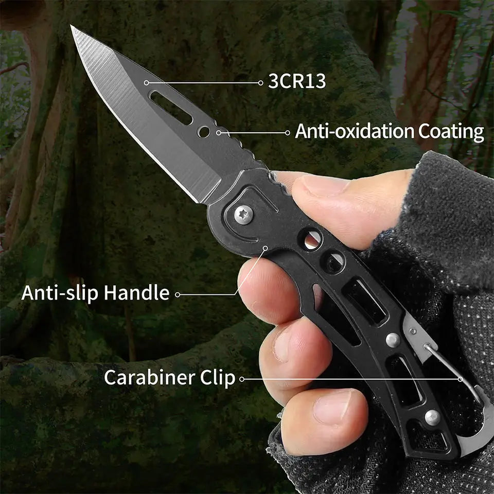 A hand holds a black folding stainless steel survival knife with an anti-oxidation coating and anti-slip handle.