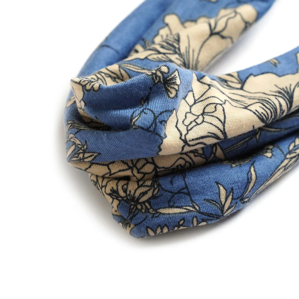 A close-up of a blue and beige patterned cotton stretch headband folded and displayed against a white background.