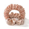 A pink satin heatless curling rod headband with gathered fabric curls.