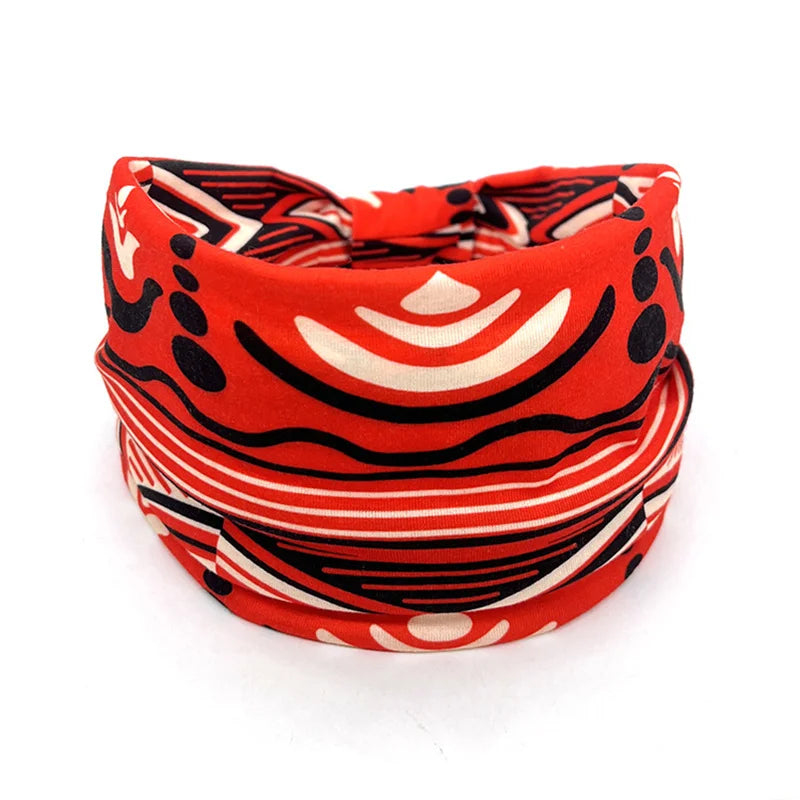 A close-up of a red and black patterned bohemian stretch cotton headband.