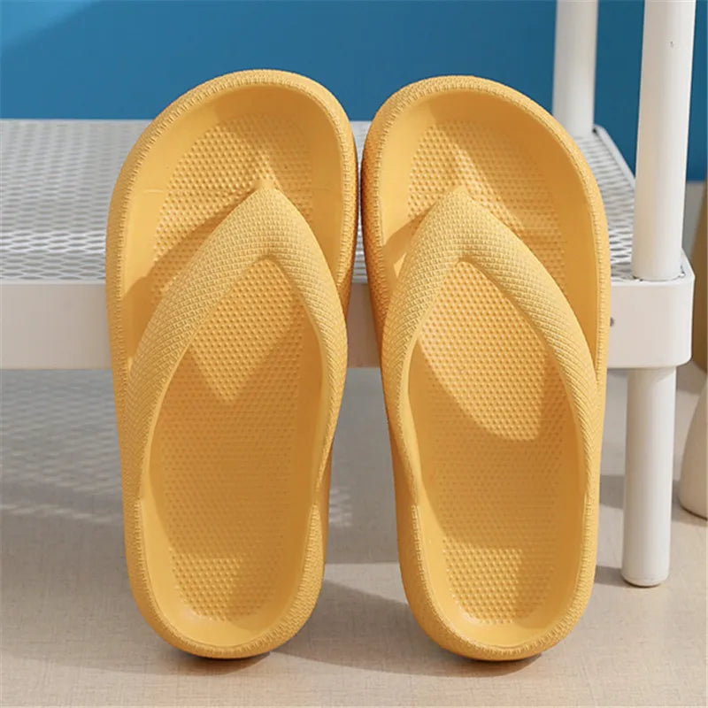 A pair of yellow comfort platform flip flops resting on a white surface.